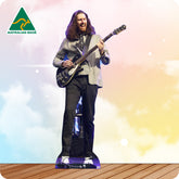 Person with long hair playing a guitar on a wooden floor with a colorful background